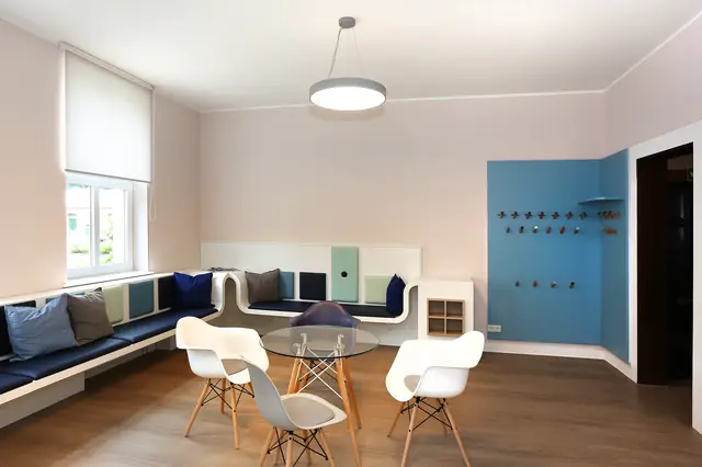 Wartezimmer der Hausarztpraxis Dr. Evers mit individuell gefertigter Eckbank, Polsterelementen und blauer Garderobenwand