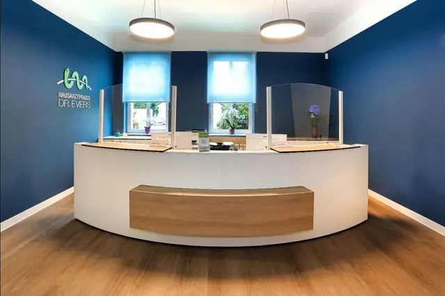 Empfangstresen einer Hausarztpraxis mit Holzfront und blauen Wänden